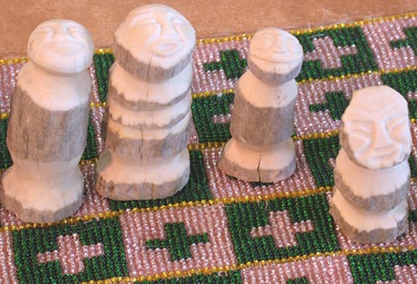 We can see a detail of the embroidered squares on which four of the pieces are resting. They are simply sculpted, without details except for the expressions of the faces.