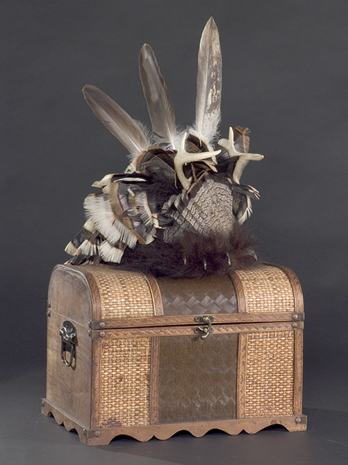 � la base de la coiffe, un bandeau fait de peau d'ours orn�e de deux griffes noires nous indique que le chef appel� � la porter est du clan de l'ours.